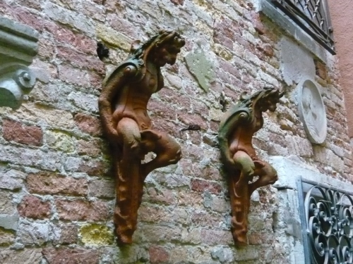 Does anyone have any fresh ideas about their purpose? They're quite large, maybe 50-60 cm tall. They are quite high up on the walls, it is hard to get the perspective correct. The hook shaped protruberances at the back of the heads look like they could support a rod of some type, between the two 'things'.